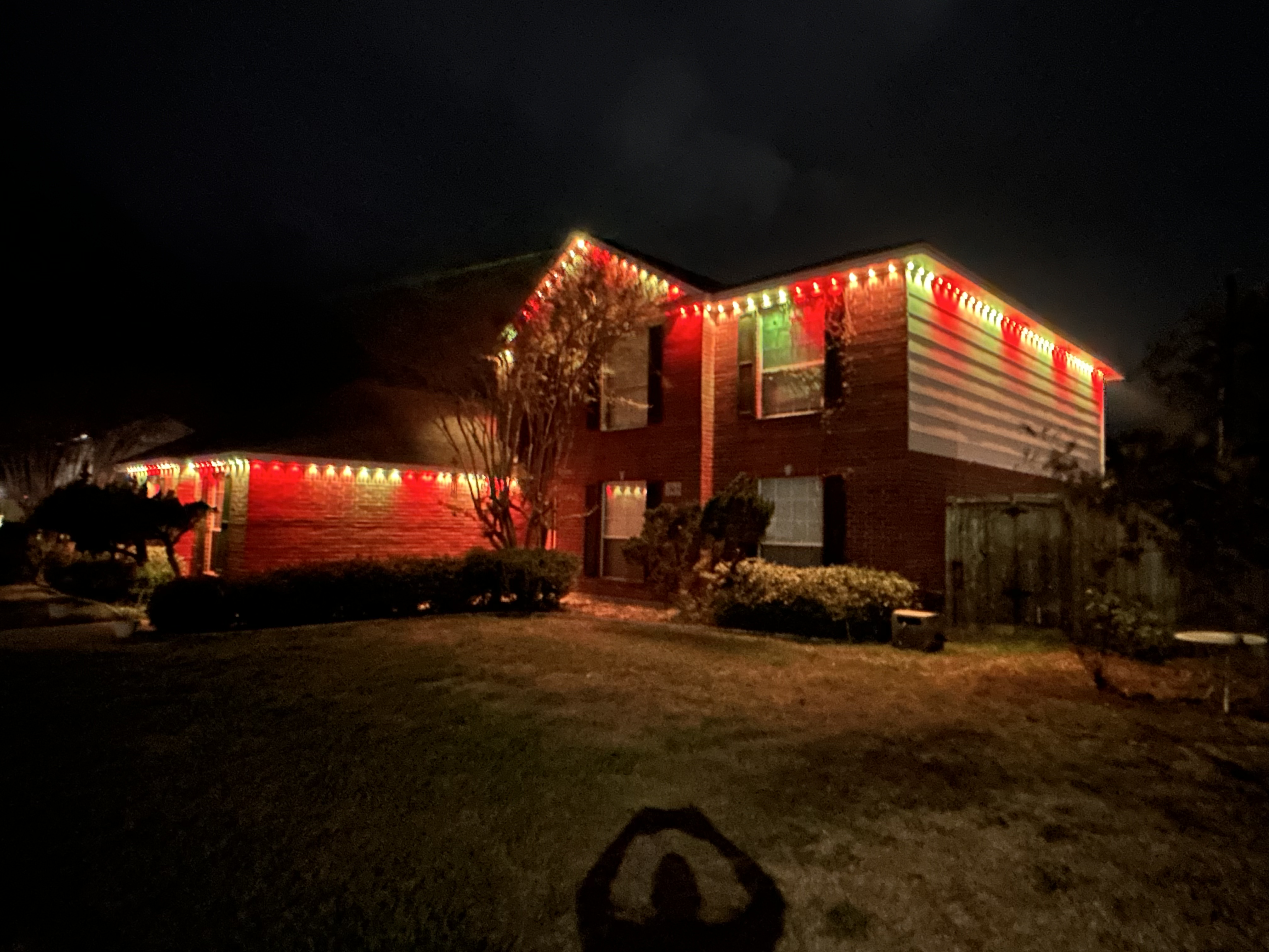 Full wrap red and green Christmas permanent lighting on two-story home by H&L